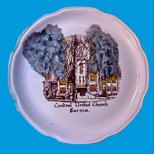 Decorative plate with a burning church illustration and text on a blue background