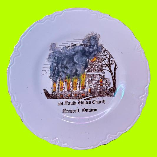 Decorative plate with a burning church painting and text on a bright green background
