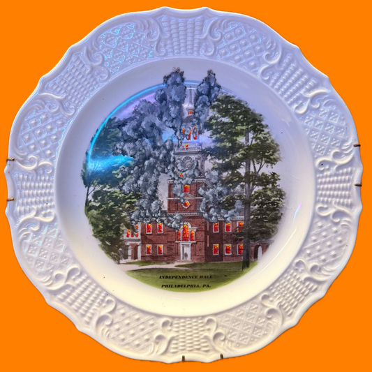 A decorative plate of independence hall in Philadelphia painted on fire.