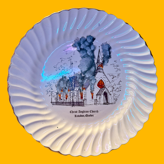 Decorative plate with a painted burning  church. Plate is on a yellow background